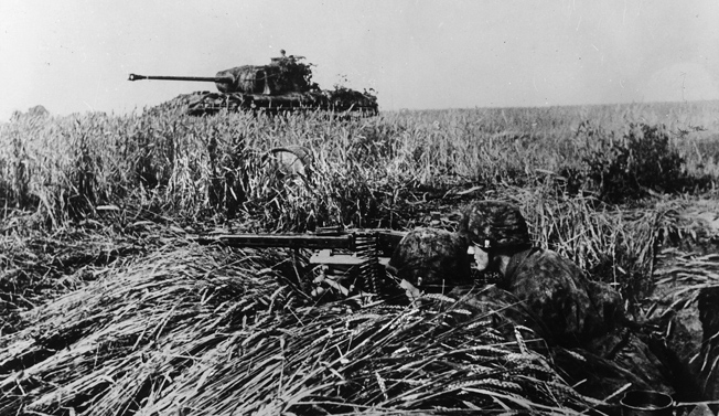 The Germans await: a pair of SS panzer-grenadiers, supported by a Panther medium tank, man their MG-42 machine gun in a field near Caen, July 1944.