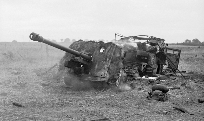 A British 17-pounder antitank gun and Morris C8 Quad artillery tractor knocked out and burning after the battle for Hill 112, July 15.